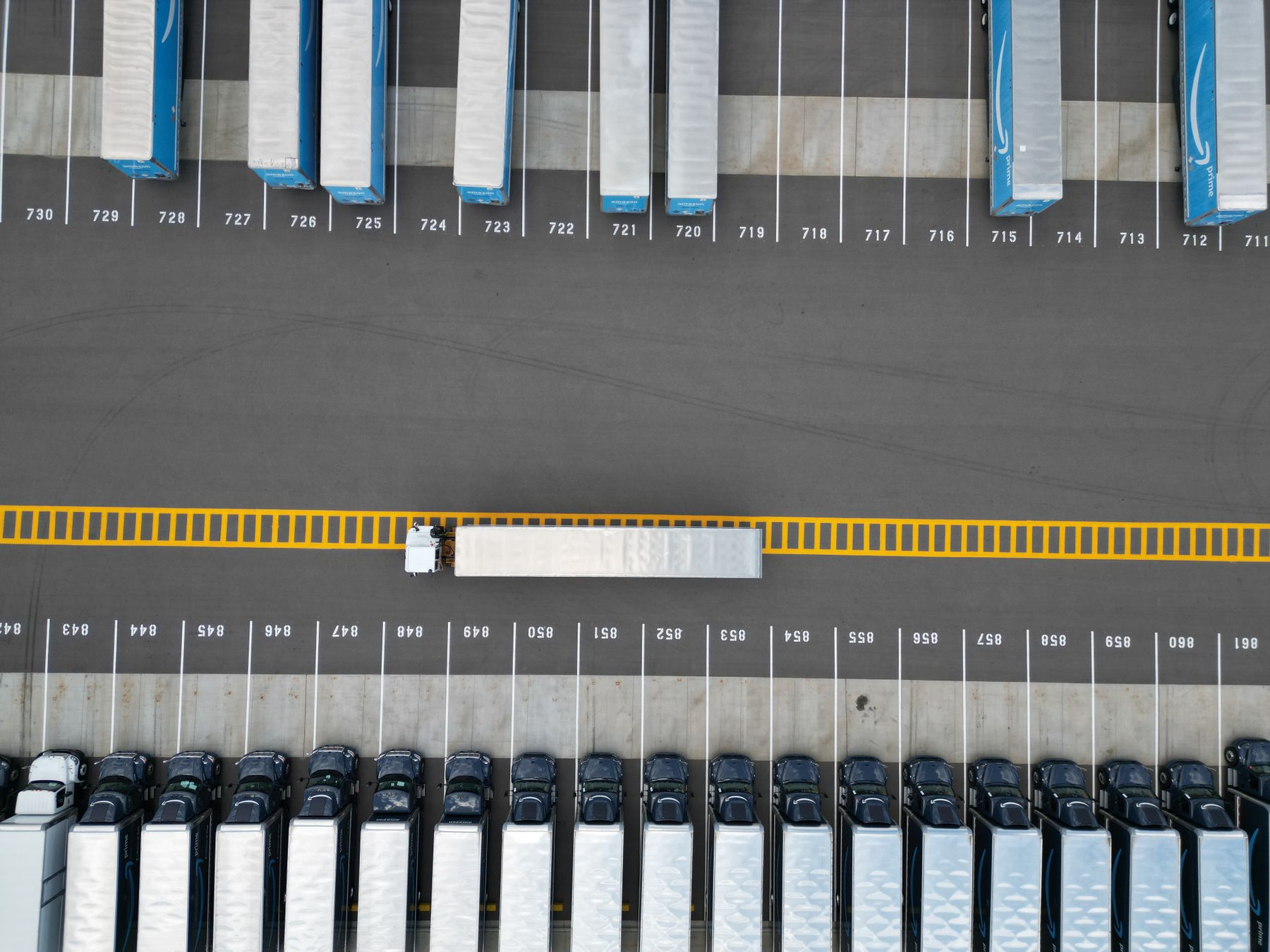 Aerial view of semi trucks and trailers arranged in a freight parking yard